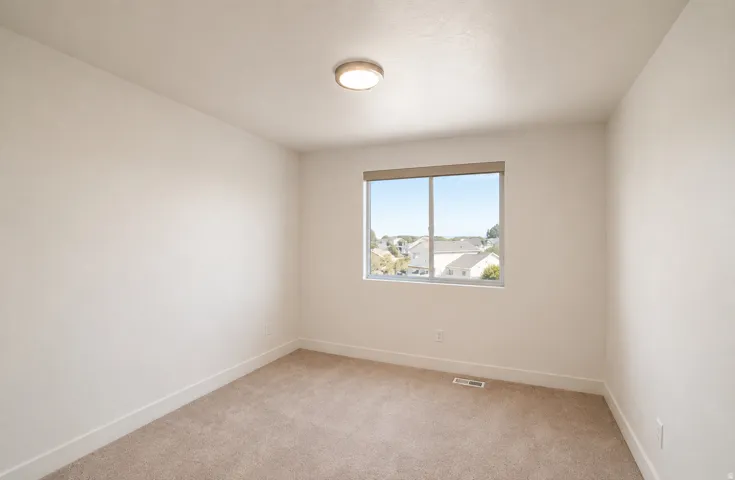 Neutral wall color, carpet flooring, recessed window, flush-mount ceiling light