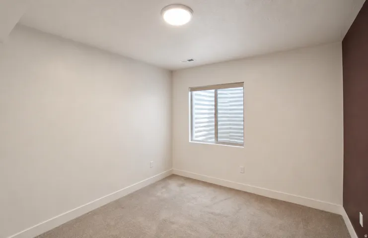 Recessed window with privacy blind, plush carpeting, contemporary ceiling light fixture, and two-tone wall finishes