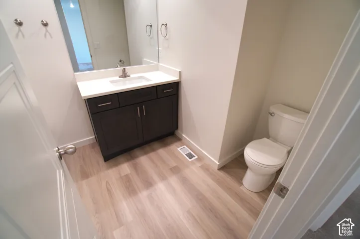 Modern vanity with a white countertop and dark wood-finish cabinetry, under-mount sink, brushed nickel faucet, and coordinating wall mirror
