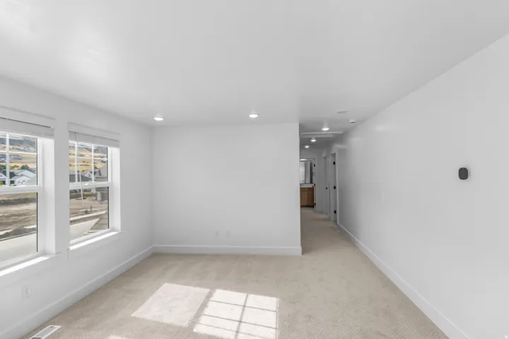 Recessed lighting, light-toned carpeting, dual windows, and white walls