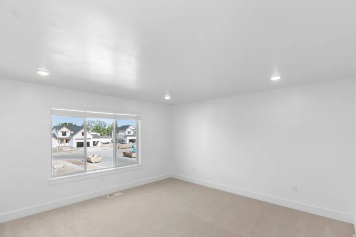 Recessed ceiling lighting, large window, neutral wall finishes, and carpeted flooring