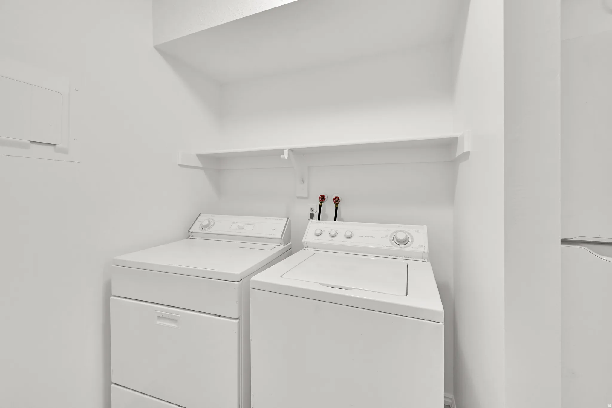 Laundry area with overhead shelving