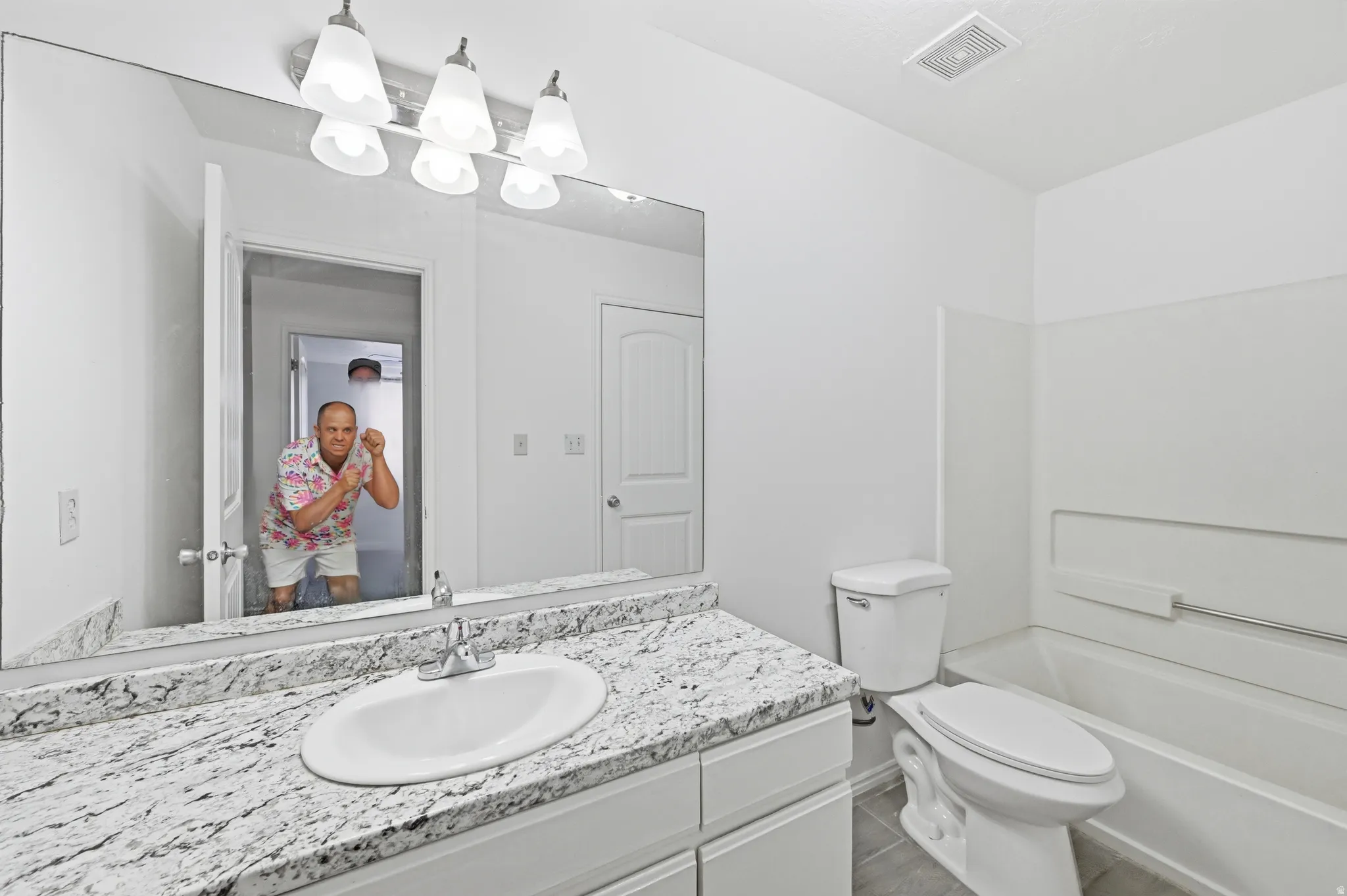 Vanity with a polished stone countertop, integrated sink, and dual-handle faucet