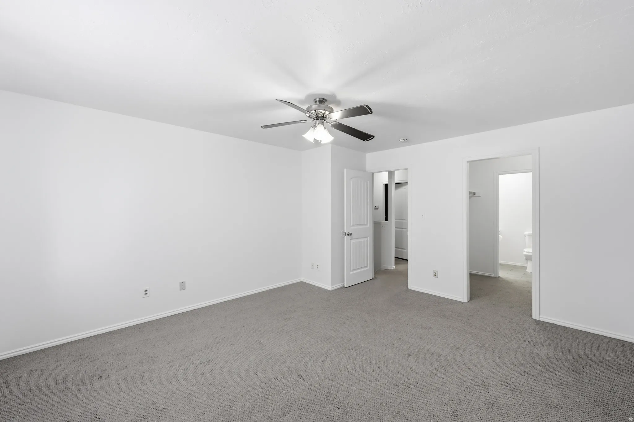 Spacious interior featuring neutral carpeting and white painted walls