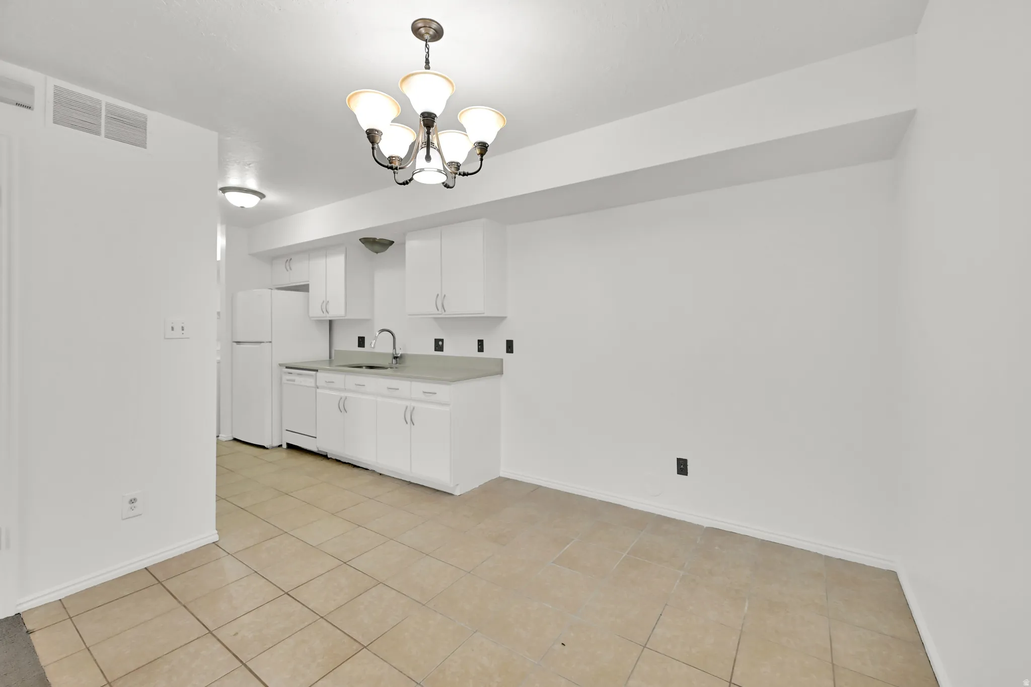 Kitchen featuring white cabinetry, light-toned countertops, and tile flooring