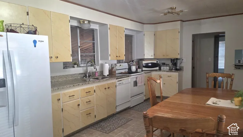 Spacious kitchen featuring painted cabinetry, stainless steel appliances, tile countertops, and a convenient pass-through window