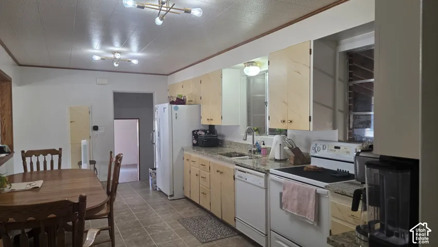 Kitchen featuring a stainless steel sink, granite countertops, painted  cabinetry, and tile flooring