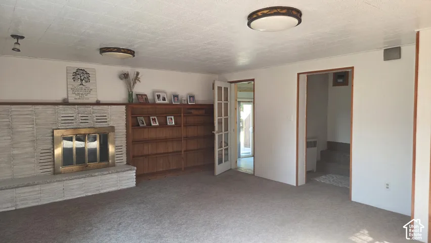 Living area featuring a natural gas fireplace with a brass firebox, built-in wood shelving.
