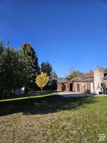 Expansive backyard featuring a paved patio area, and mature trees