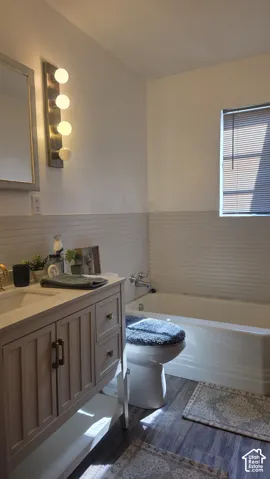 Updated Bath next to Master bdrm. Vanity with integrated sink, bathtub, and wood-finish flooring