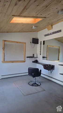 Salon. Wood-finish plank ceiling with a skylight and recessed lighting