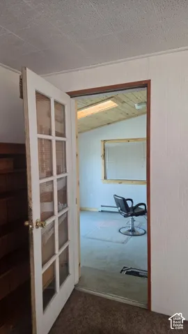 Room featuring a skylight, vaulted wood-paneled ceiling