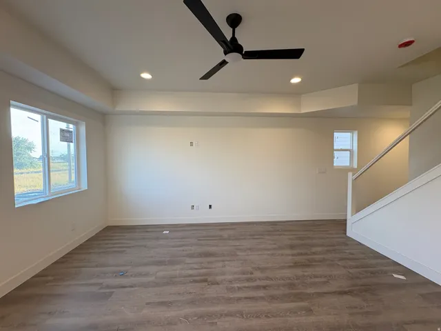 Wood-finish flooring, recessed lighting, and a contemporary ceiling fan