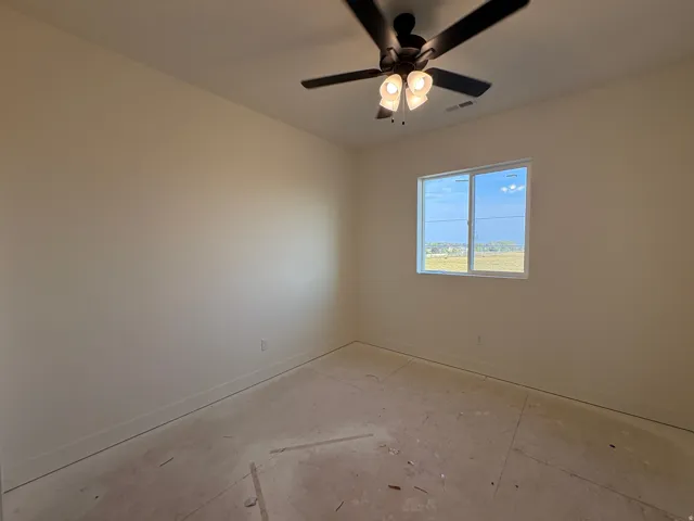 Ceiling fan with integrated lighting, neutral wall tones, and a double-pane window