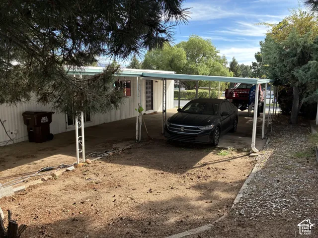 Carport with white support columns and a light blue roof