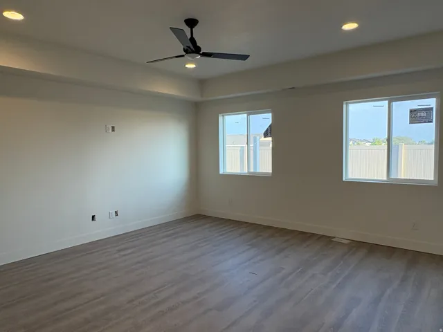 Recessed lighting, wood-finish flooring, two windows, and a ceiling fan