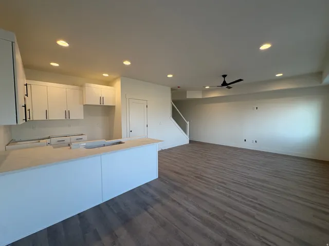 Open-concept living area with wood-finish flooring, recessed lighting, and a ceiling fan