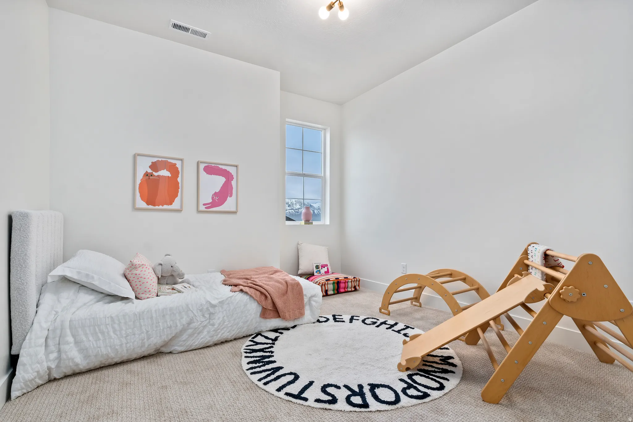 Recessed lighting, light-toned carpeting, and a single window with white trim