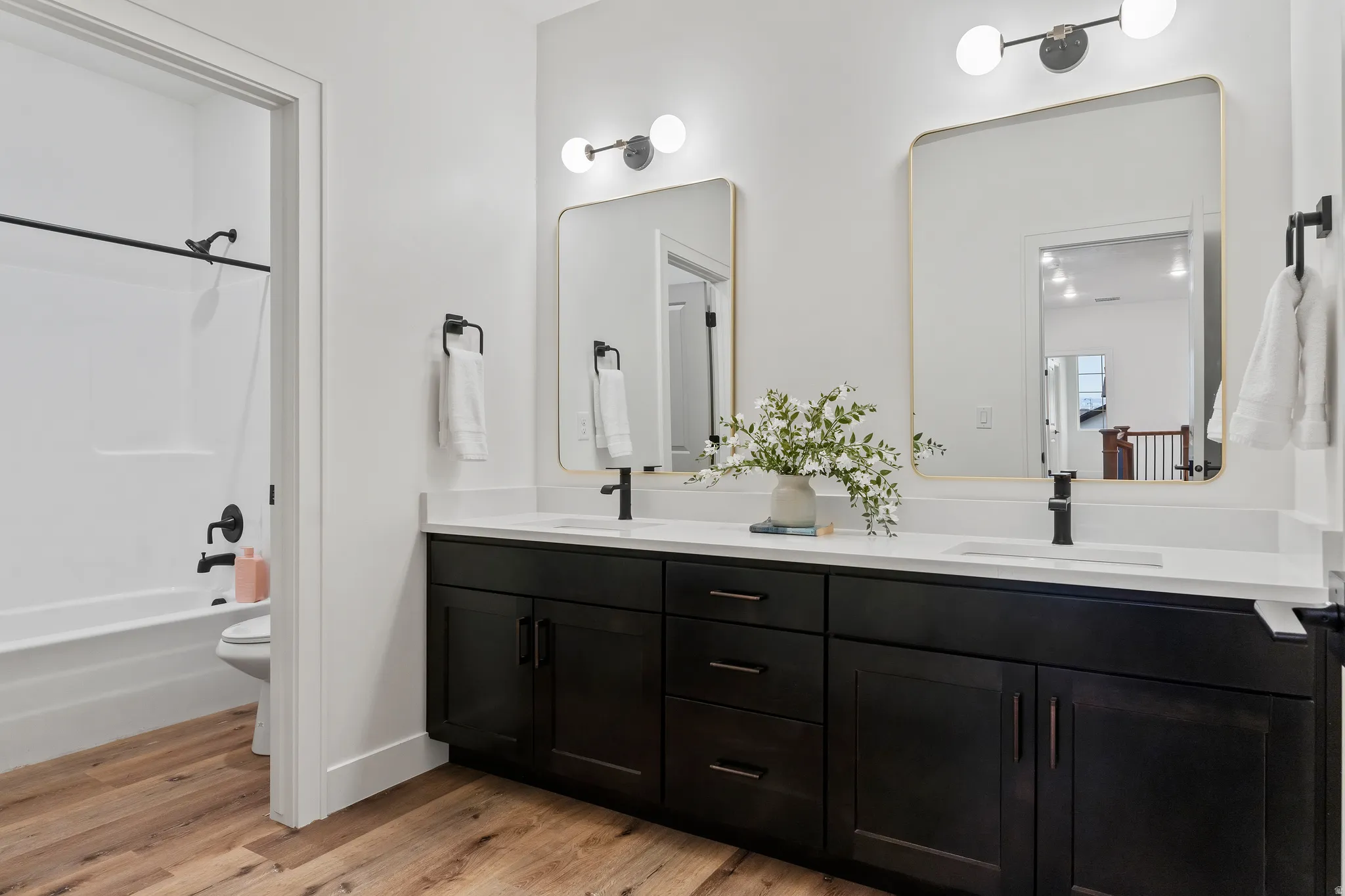Dual vanity with dark wood cabinetry and white countertops