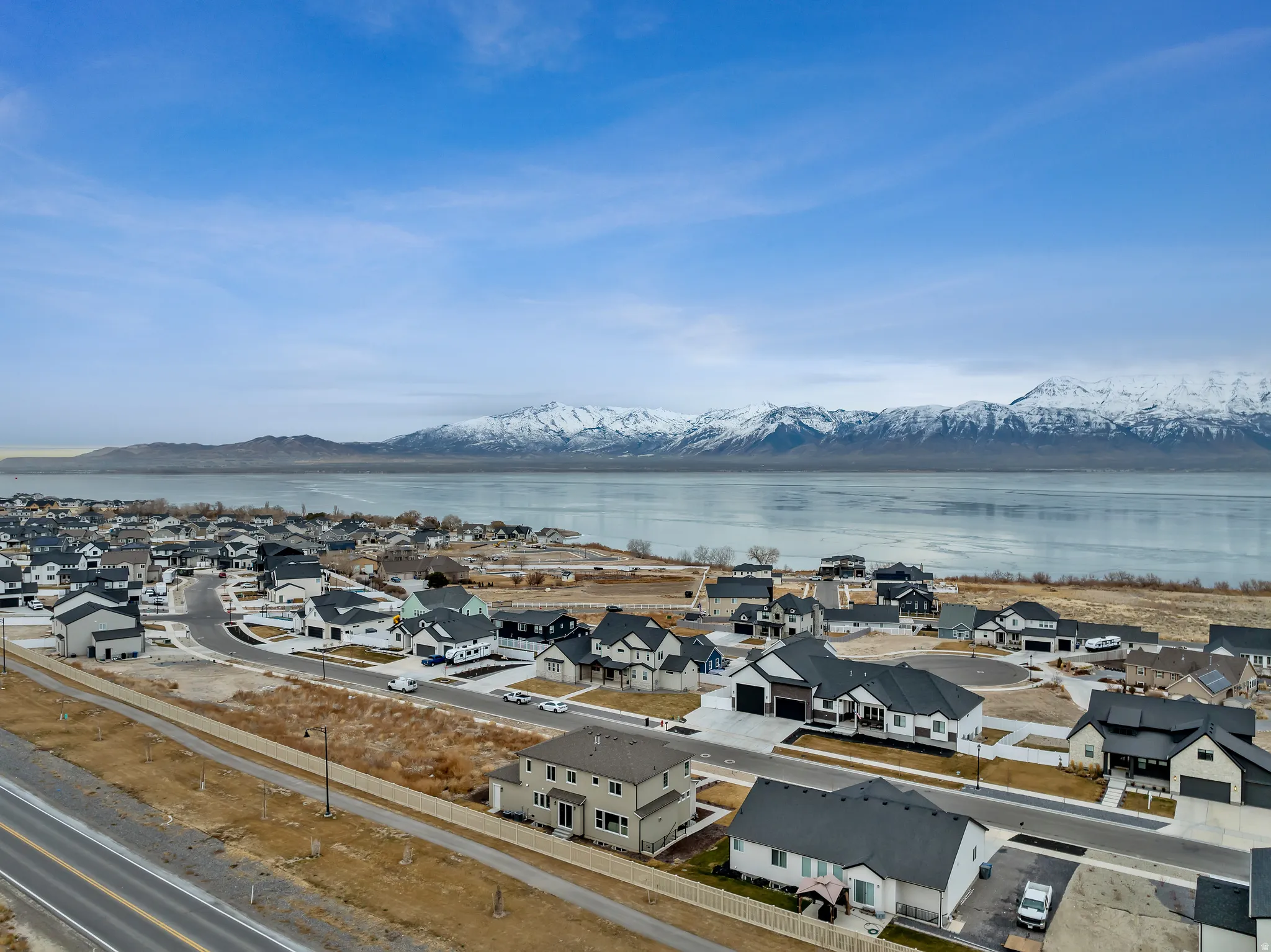 Mountain backdrop, expansive body of water, road, residential development, and cul-de-sac