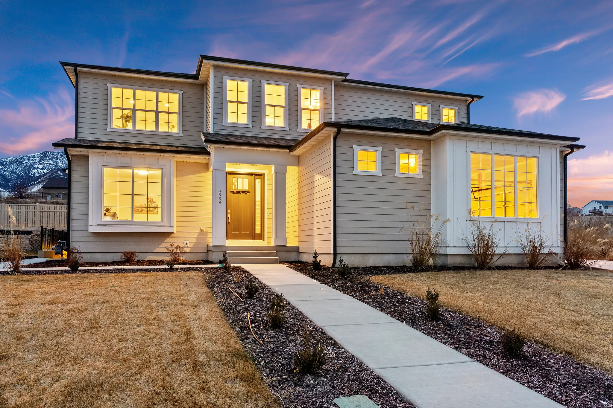 Contemporary two-story residence with a gray siding exterior and white trim accents