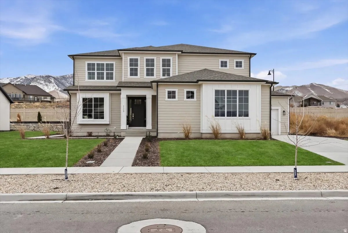 Contemporary-style home featuring light-colored siding, a dark asphalt shingle roof, and multiple large windows