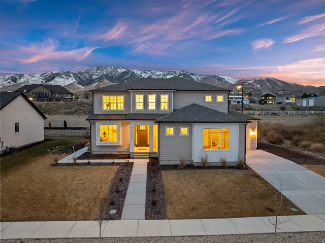 Modern two-story residence with a concrete walkway, attached garage, and mountain backdrop