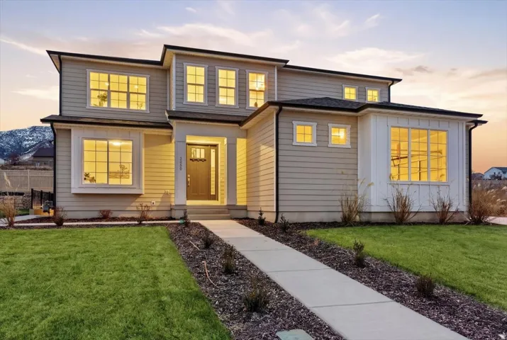Contemporary multi-story residence with a concrete walkway, established landscaping, and siding exterior