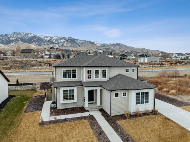 Two-story residence with light-toned siding and dark shingle roofing