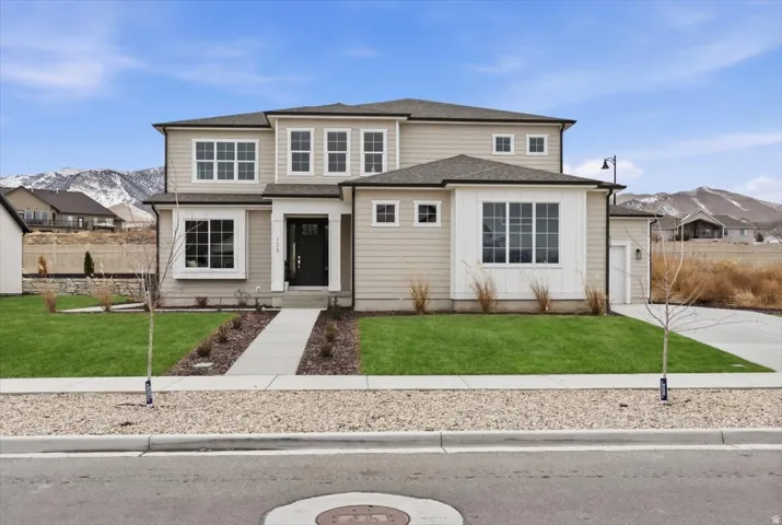 Contemporary-style home featuring light-colored siding, a dark asphalt shingle roof, and multiple large windows