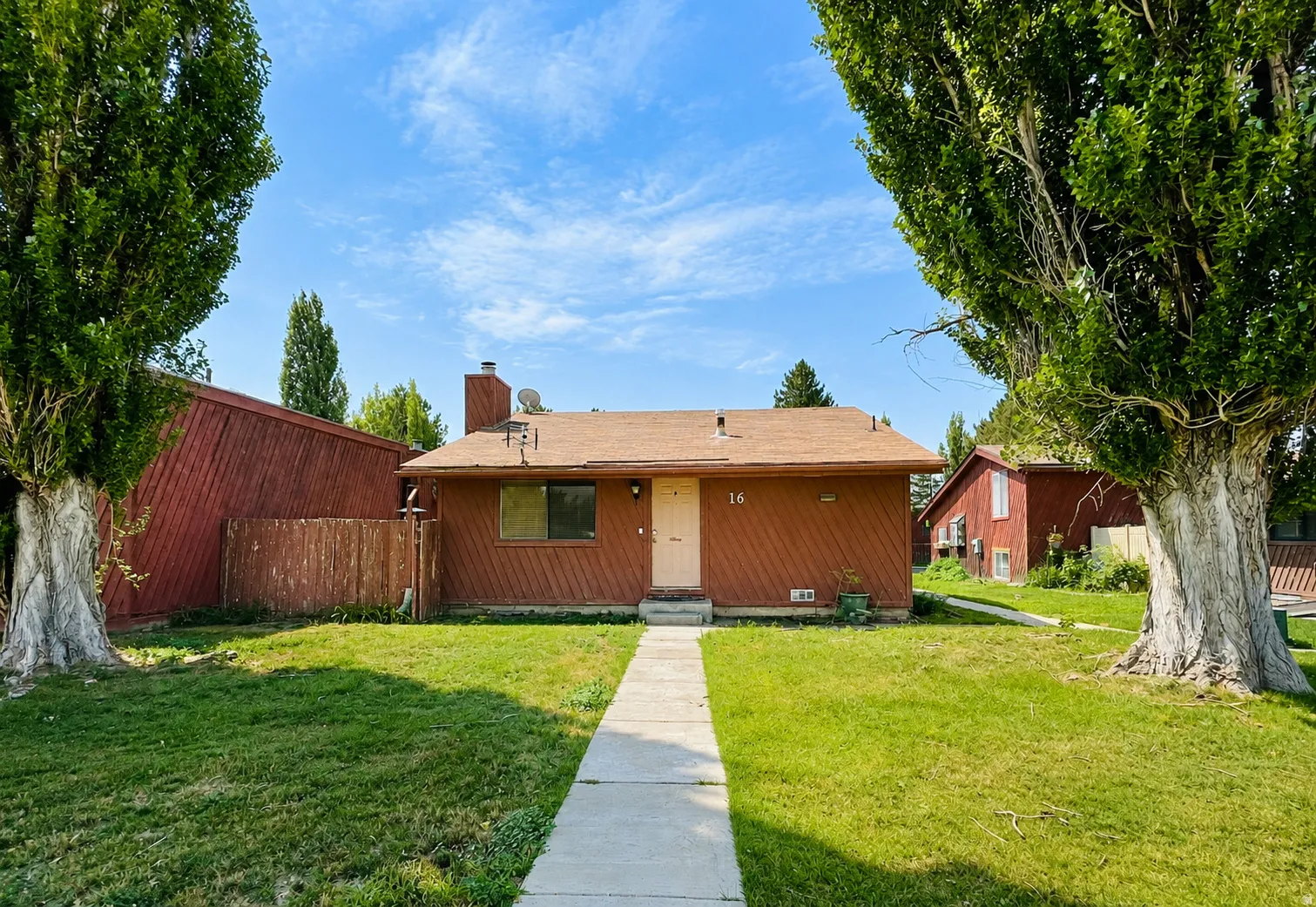 Front exterior with your own street access, a spacious yard, mature trees, and cedar siding.