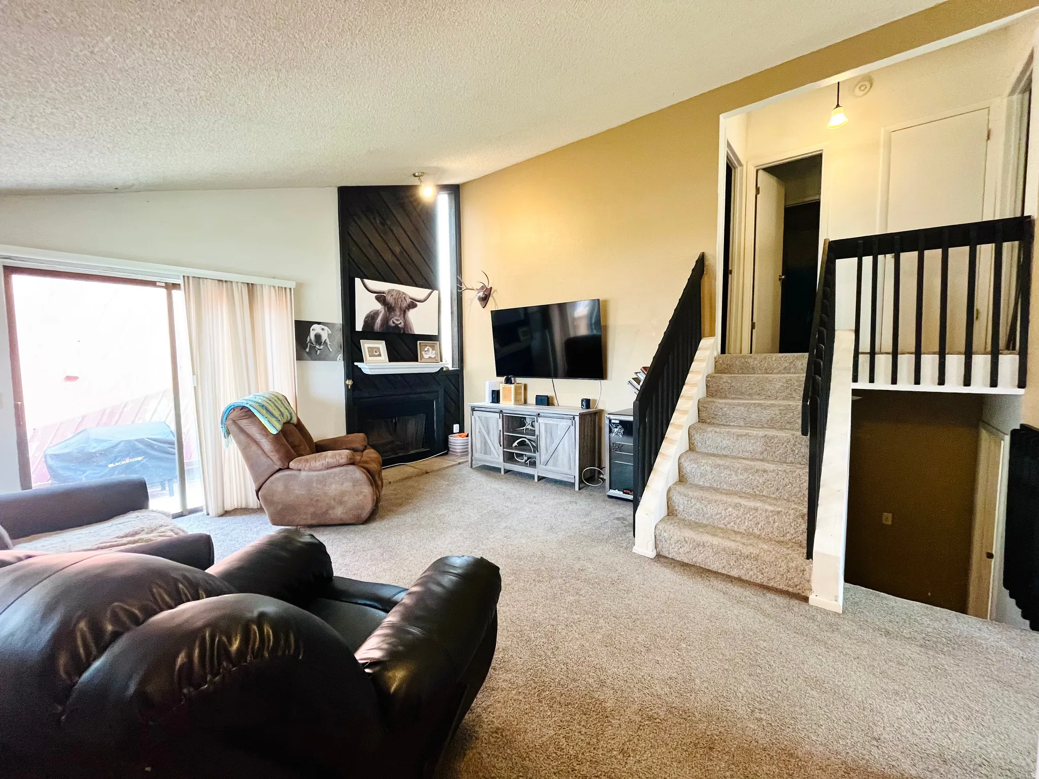Beautiful formal living room offering vaulted ceilings, sliding glass door, and a warm gas fireplace.
