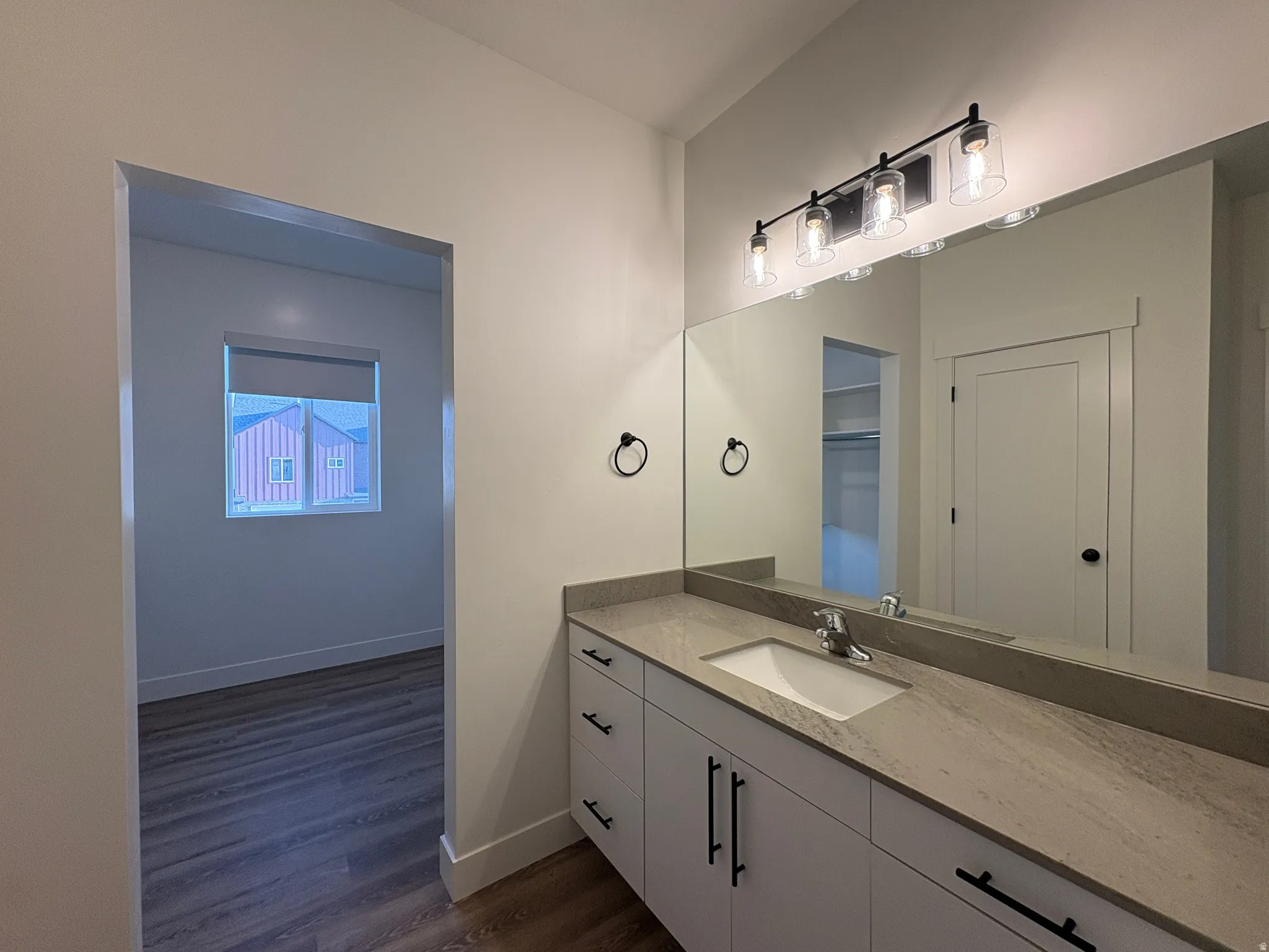 Modern vanity with an integrated sink, expansive countertop, and matte black hardware