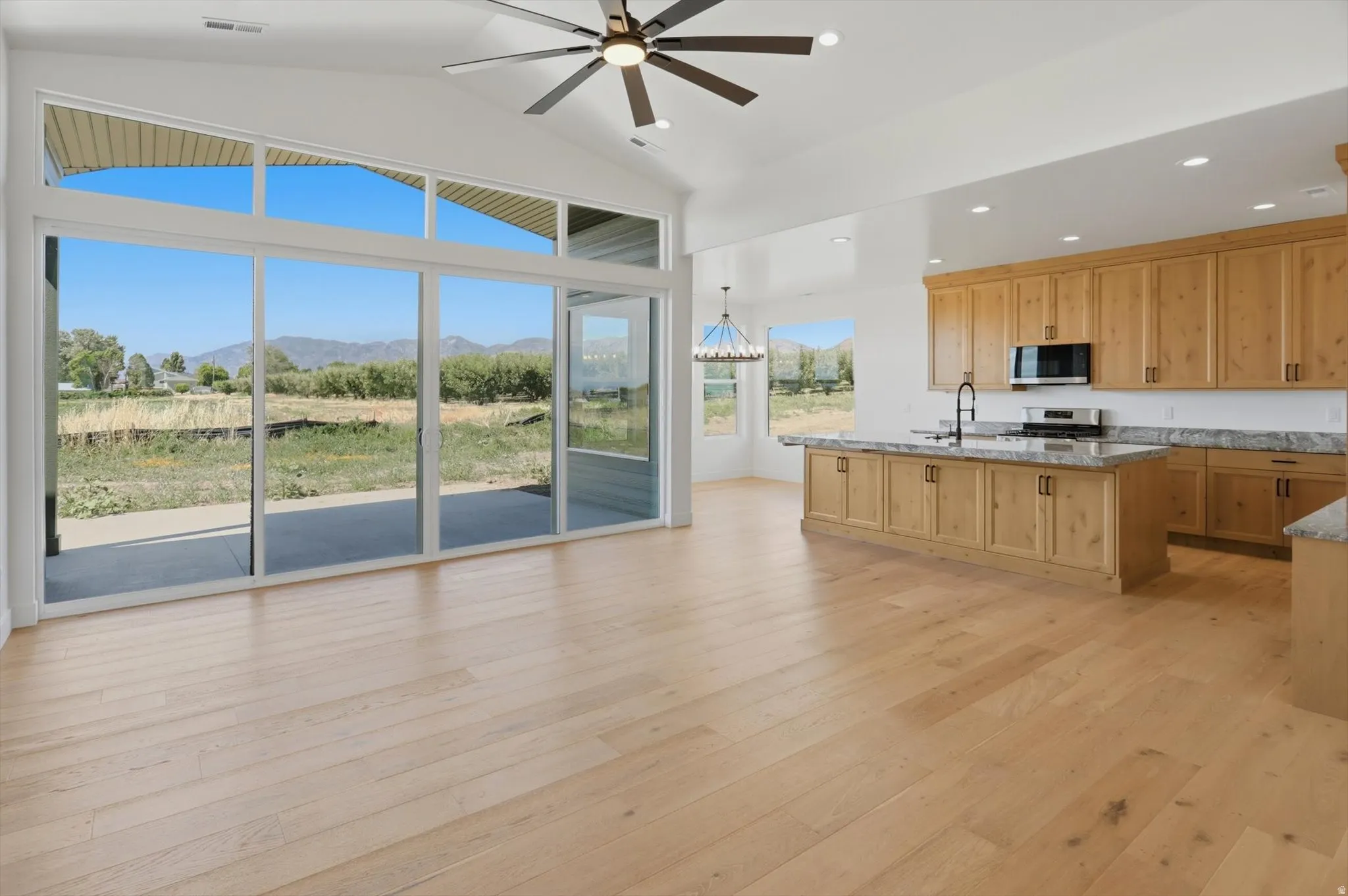 Wood-finish flooring throughout, vaulted ceiling, and expansive sliding glass doors