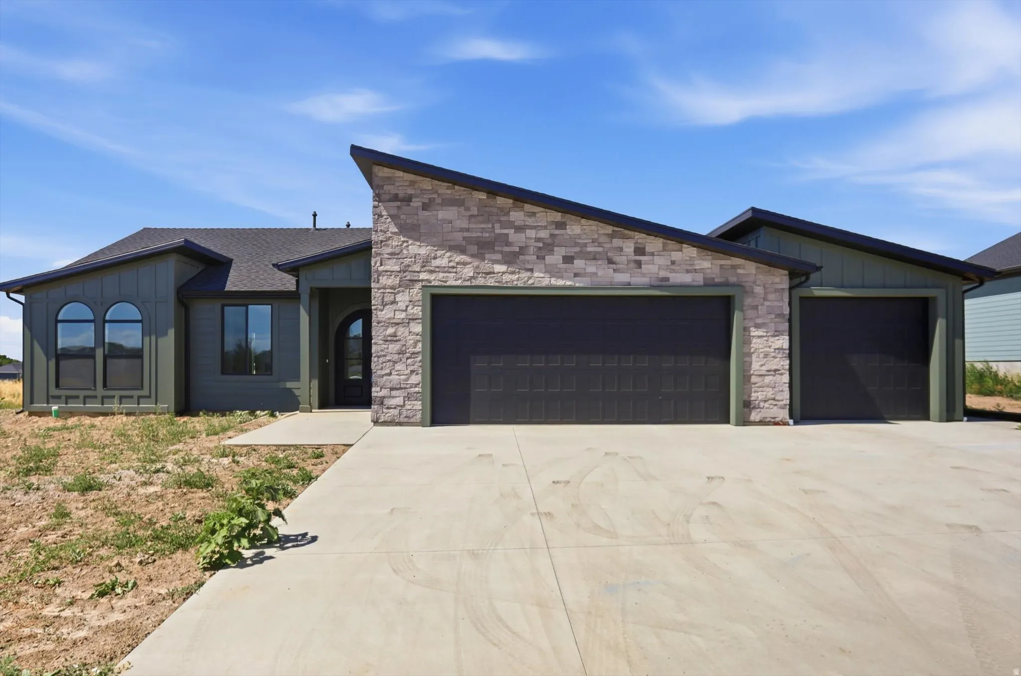 Contemporary exterior with board and batten siding and stone accents