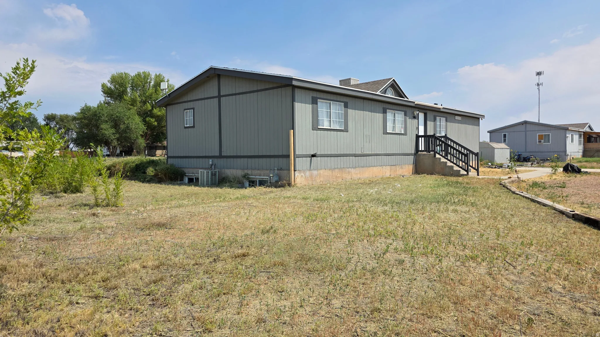 Gray siding exterior with white trim windows and a dark roof