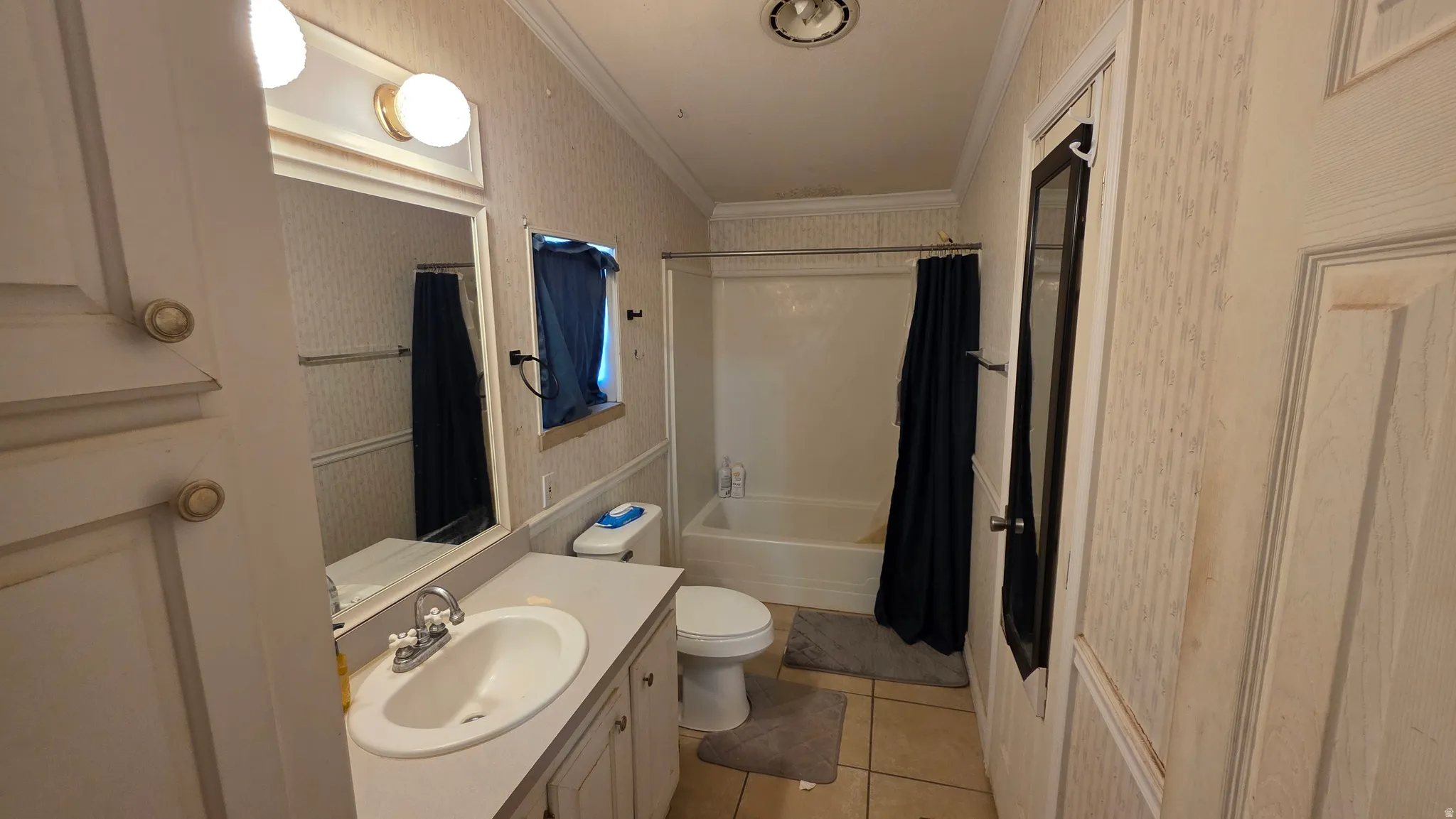 Vanity with integrated sink, wall-mounted mirror, and overhead lighting