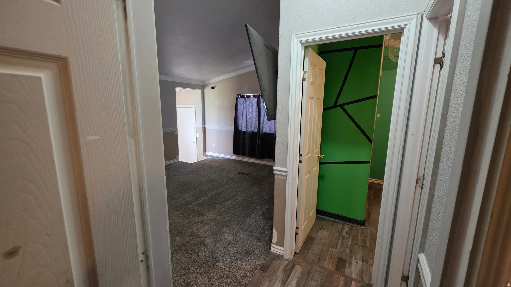 Carpeted living area with crown molding