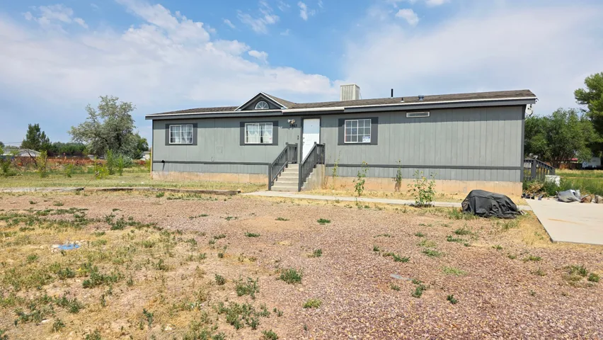 Single-story residence featuring light gray siding, white trim, and a dark gray roof