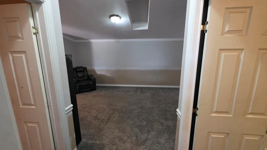 Carpeted flooring, vaulted ceiling, crown molding, and recessed lighting