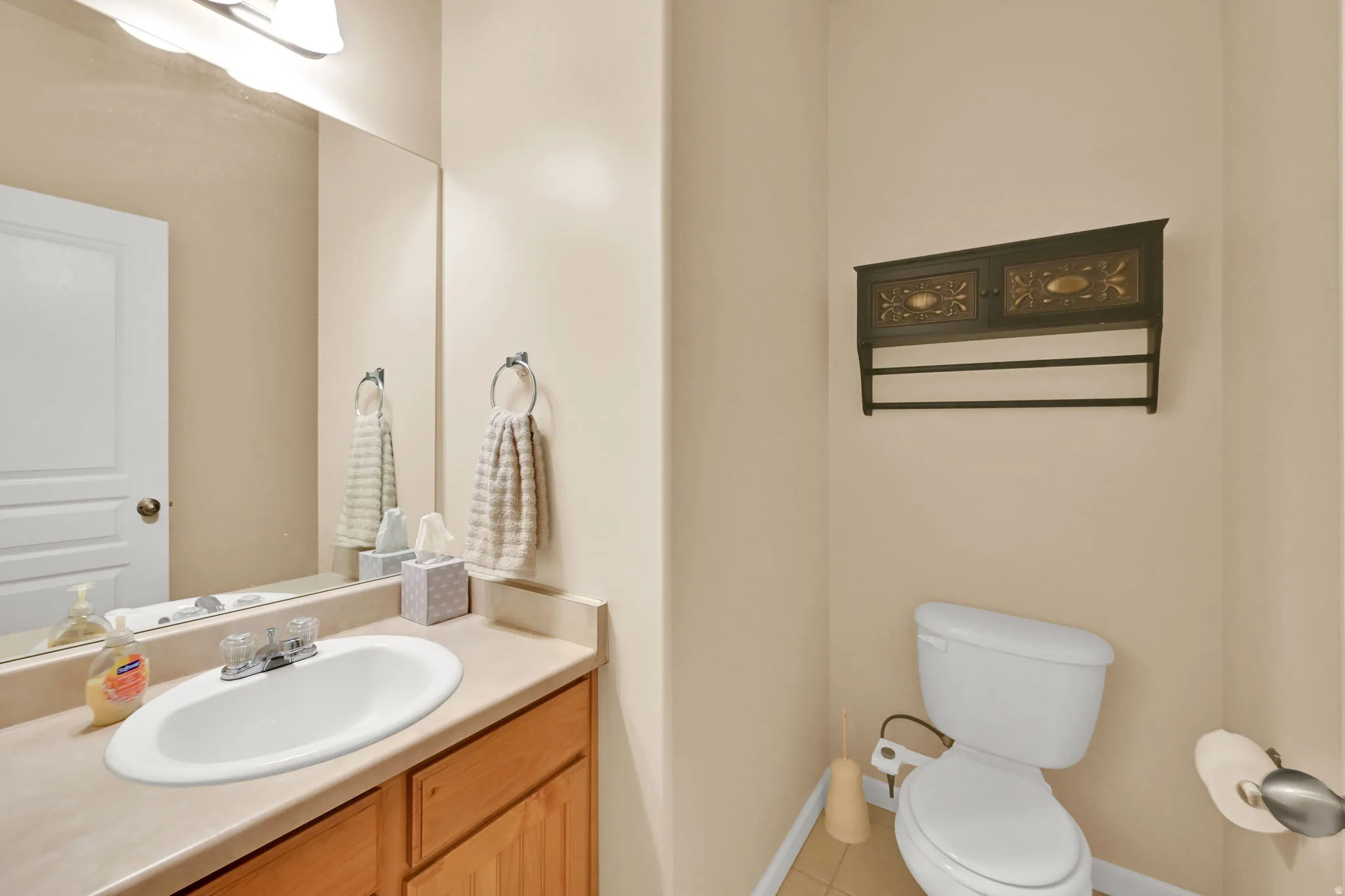 Vanity with an integrated oval sink, laminate countertop, and wood-finish cabinetry