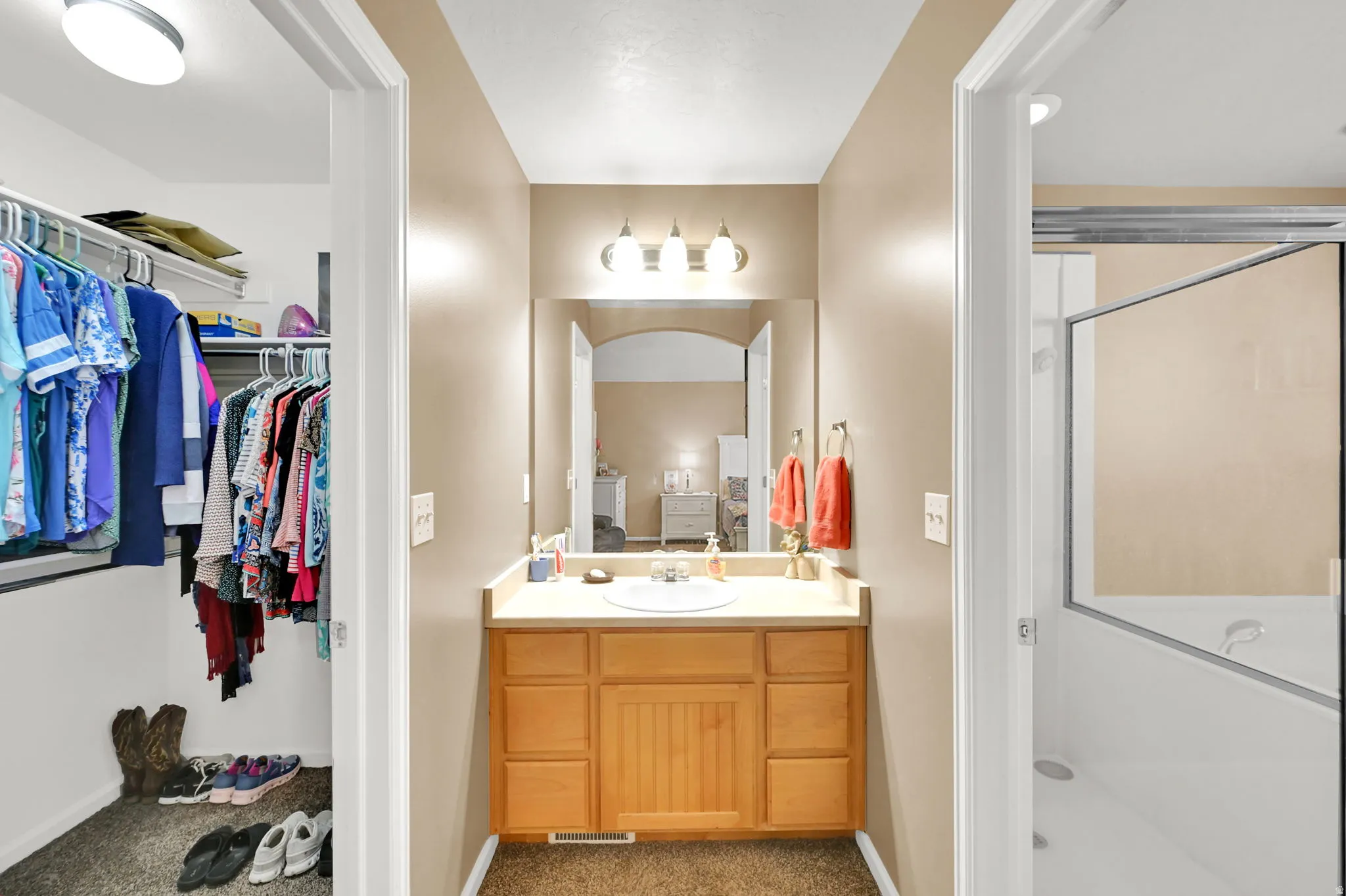 Vanity with integrated sink, wood-finish cabinetry, and overhead lighting