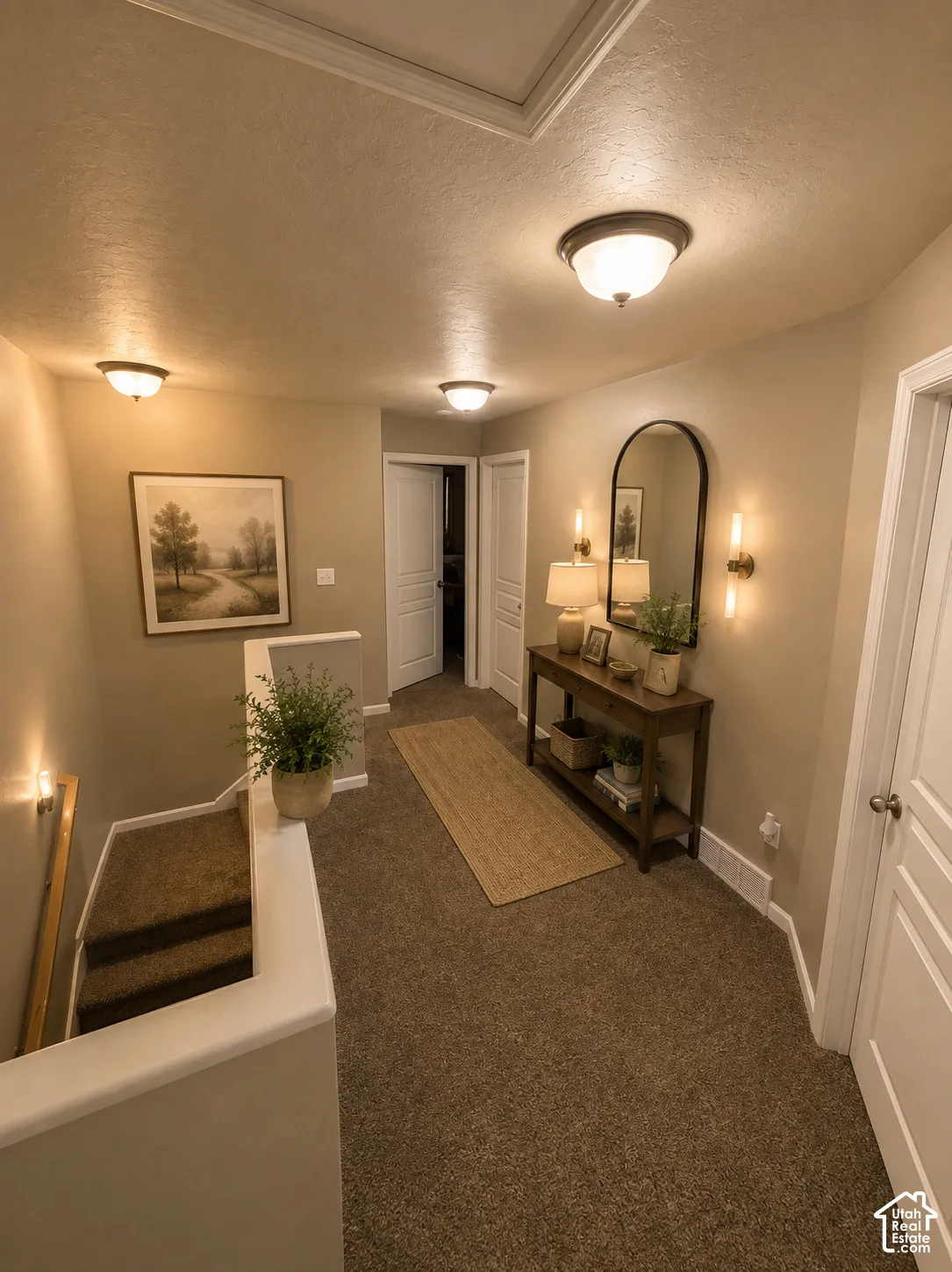 Carpeted hallway with flush-mount lighting, wall sconces, and white paneled doors