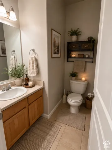 Vanity with a single basin sink and a chrome faucet set, wood-finish cabinetry, neutral-toned countertop, wall-mounted light fixture, and tile flooring