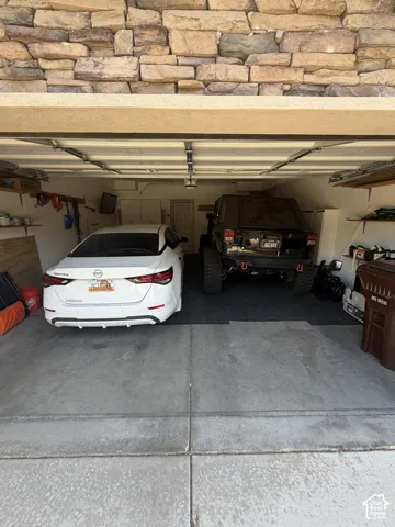 Two-car garage with overhead lighting and a stone-clad exterior