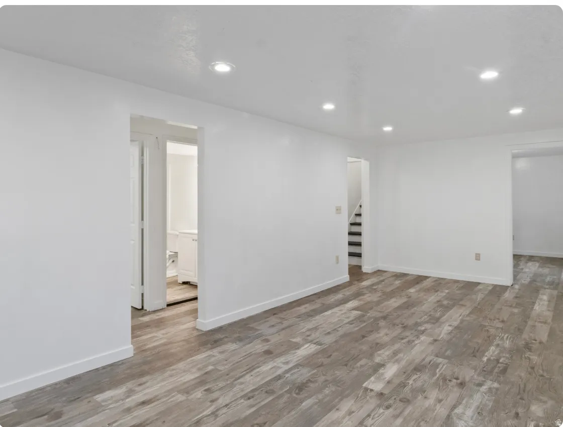 Recessed lighting illuminates the wood-finish flooring