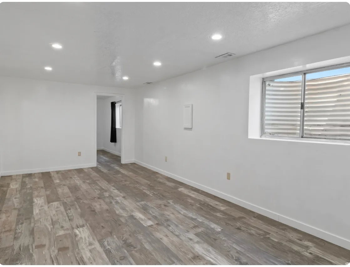 Recessed lighting illuminates the wood-finish flooring