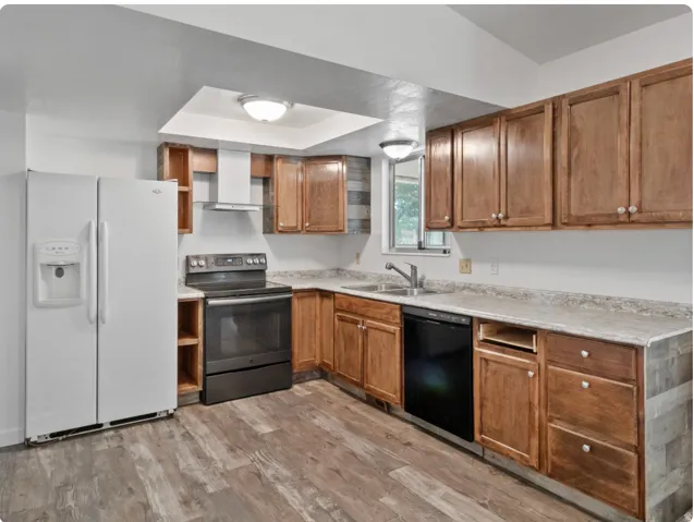 U-shaped kitchen with wood-finish flooring, wood cabinetry, and a stainless steel sink