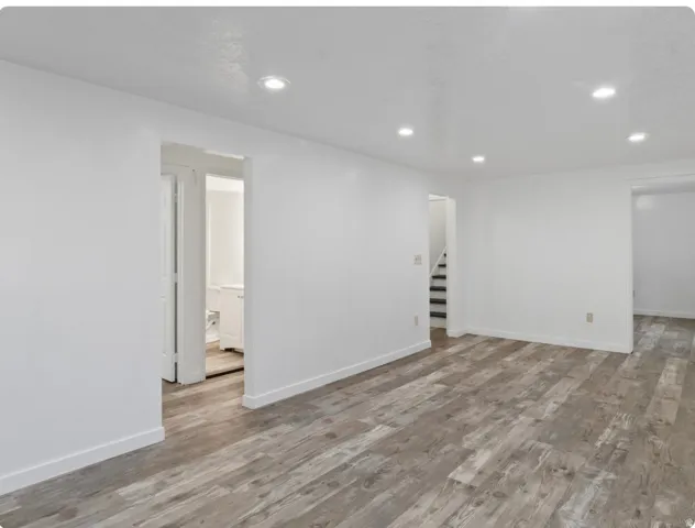 Recessed lighting illuminates the wood-finish flooring