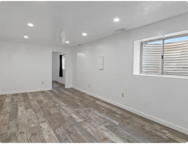 Recessed lighting illuminates the wood-finish flooring